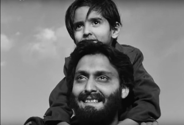 Apu carrying his young son on his shoulders.