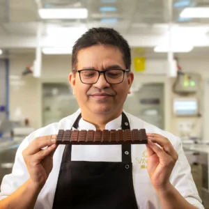 A Chocolatier Holding a Bar of Chocolate at Smoorland Bangalore Factory.