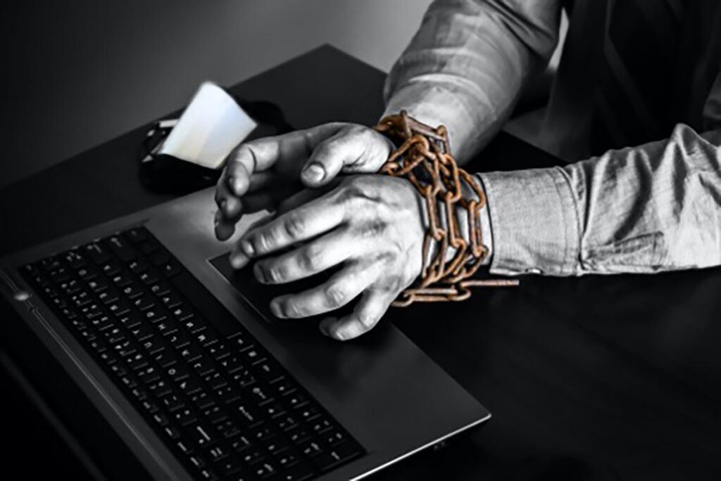 Shackled hands forced into cyber slavery.
