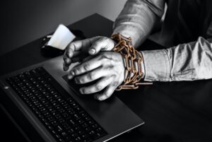 Shackled hands forced into cyber slavery.