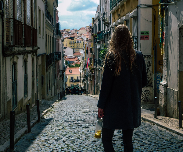 solo-female-travel-2026-—-woman-walking-alone-in-Lisbon-colourful-streets