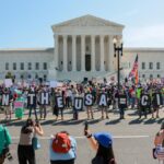 Demonstrators outside the U.S. Supreme Court holding “BORN IN THE USA = CITIZEN!” in a birthright citizenship protest.