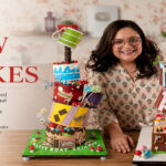 Chef Aditi posing with her custom-designed cakes as a professional cake artist.
