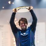 Magnus Carlsen holding the Esports World Cup trophy after his victory.