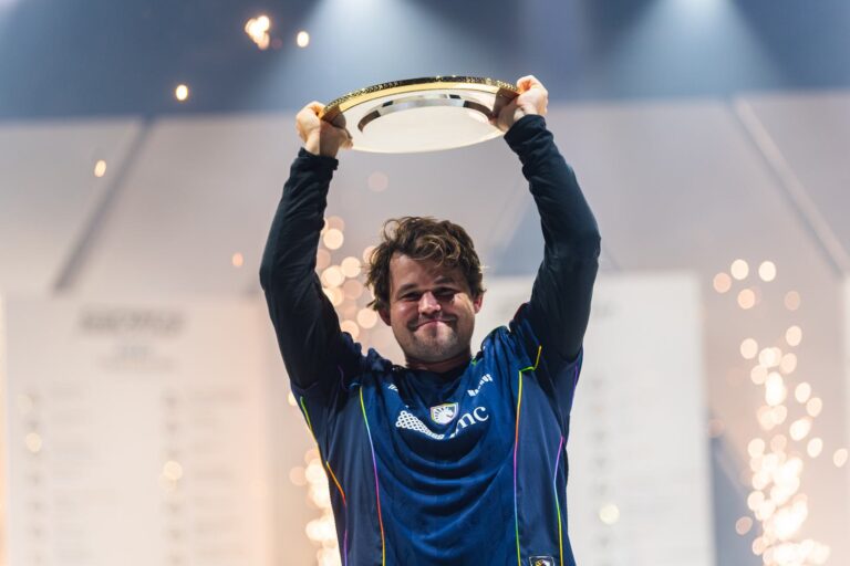 Magnus Carlsen holding the Esports World Cup trophy after his victory.
